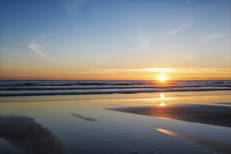 Atlantic ocean sunset with surging waves at Fonte da Telha beach, Costa da Caparica, Portugal,