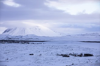 Snow-covered extinct volcano Hverfjall, lonely farmhouse in front, near Lake Myvatn, Northern