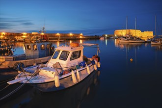 Venetian Fort castle in Heraklion and moored Greek fishing boats in port, Crete Island, Greece in