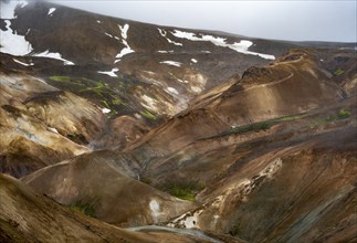 Steaming streams between colourful rhyolite mountains in the Hveradalir geothermal area,