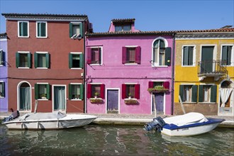 Colourful houses on the canal, canal with boats and colourful house facades, Burano Island, Venice,