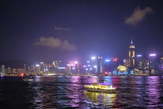 Hong Kong skyline cityscape downtown skyscrapers over Victoria Harbour in the evening illuminated