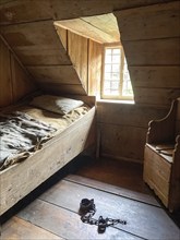 Prison cell in historic rebuilt town hall with left bed with bed linen bedding of coarse linen in