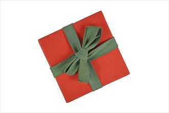 Top view of red Christmas gift box with green ribbon on white background