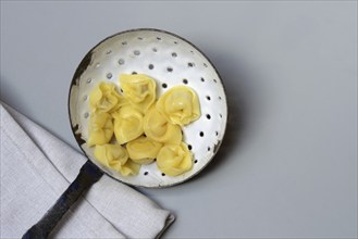 Cappelletti, cooked pasta in a sieve ladle, pasta