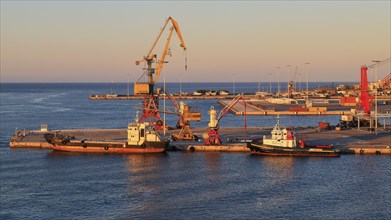 Evening light, pier, loading cranes, tugboats, port, Heraklion, capital, island of Crete, Greece,