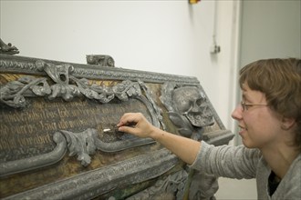 Restorer at Fuchs&Gierke, here a metal sarcophagus from a family vault is expertly cleaned and