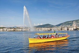 The Jet d'eau, and the Mouettes genevoises in sunshine and blue sky, landmark in the Geneva harbour