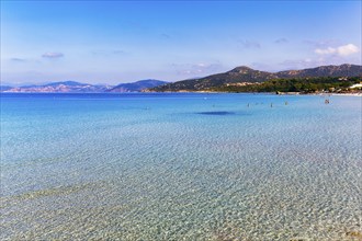 Turquoise blue clear water, coastline with hills on the horizon, L'Île-Rousse, Ile Rousse,