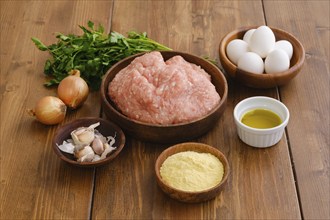 Overhead view of minced meat and ingredients for homemade meatballs on a table