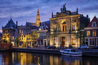 Canal with boats and houses illuminated in the evening. Haarlem, Netherlands