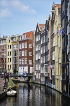 AMSTERDAM, NETHERLANDS, MAY 7, 2017: Amsterdam canal with boat, bridge and old houses with Gay