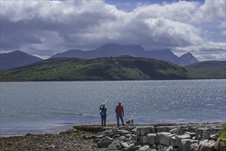 Tourists looking over Ben Loyal and Kyle of Tongue, shallow sea loch in northwest Highland,