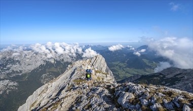 Mountaineer on a rocky narrow mountain path with mountain panorama, mountain tour to the summit of