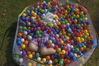 Little girl in a colourful ball pool, Lower Saxony, Germany, Europe