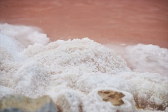 Salt crust at the waters edge of a little salt water pond for industrial salt production,