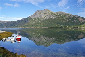 Small fishing boats and steep mountains reflected in the water of a nature harbour, Jektvik, FV 17,