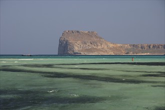 Lagoon, green sea, ship, tourist in the water, Venetian sea fortress Gramvoussa, peninsula