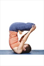 Sporty fit yogini woman practices inverted yoga asana Urdhva padmasana, lifted lotus pose isolated