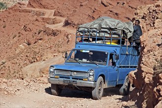 Transport with heavily loaded four-wheel drive pick-up truck on mountain trail through the Atlas