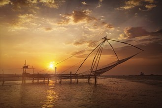 Kochi chinese fishnets on sunset. Fort Kochin, Kochi, Kerala, India. With light leak and lens flare