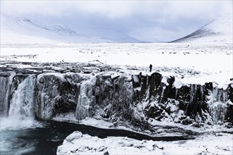 Iced and snow-covered rock face at Godafoss waterfall, snowy landscape, Northern Iceland Eyestra,