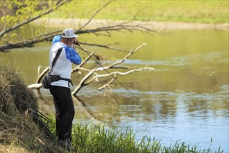 Fisherman trying to do a perfect cast, throwing lure. Spining fishing, angling, catching fish.