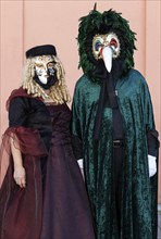 Venetian carnival masks and costumes at the Venetian fair on the historic market square,