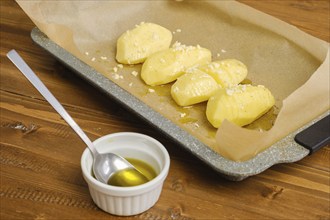 Sliced hasselback potato on a parchment in baking tray