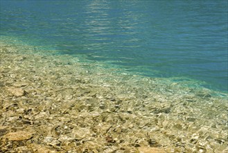 Fascinating play of colours and shapes of the clear water of Lake Walen at the edge of the shore,