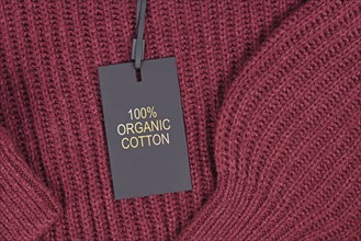 Label saying '100% organic coton' attached to environmental friendly produced pullover