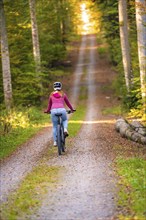 Woman on Ebike through the autumn forest, Black Forest, Gechingen, Germany, Europe