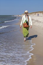 Elderly woman walking barefoot on the beach, Darßer Ort, Born a. Darß, Mecklenburg-Vorpommern,