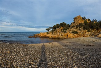 Lonely picturesque beach and red rocks, Spiaggia Su Sirboni, sunset, near Tertenia, Province of