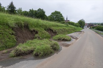 Symbolic image of climate change, slippery slope on a country road after heavy rainfall, near