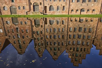 Salt warehouse, historic brick buildings, reflections on the water surface of the Trave, Hanseatic