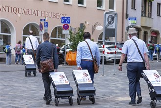 People on the move with their advertising trolleys in the pedestrian zone, Nuremberg, Middle