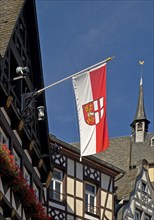 Half-timbered houses and flag with town coat of arms on the market square, Cochem,