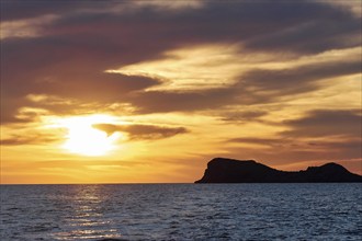 Black rocky coast orange hillem, grey clouds, sunset, dusk, Marettimo, Egadi Islands, Sicily,