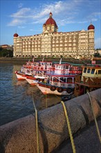 MUMBAI, INDIA, OCTOBER 31, 2019: Tourist boats in front of the famous Taj Hotel in the morning