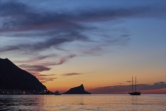 Sunset, dusk, grey clouds, sailboat, Castello di Punta Troia, boat tour, view from the sea,