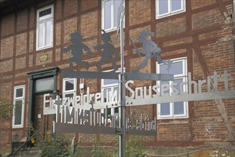 Max and Moritz with Schneider Böck in front of the Wilhelm bush House Museum with inscription one