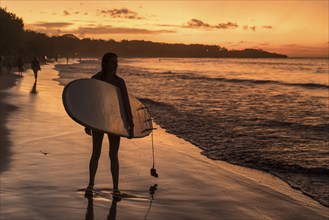 Surfers at sunset at Playa Tamarindo, Peninsula de Nicoya, Guanacaste, Costa Rica, Central America