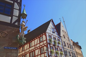 In the historic centre of Nuremberg, St. George as dragon slayer at Pilatus House (left) and houses