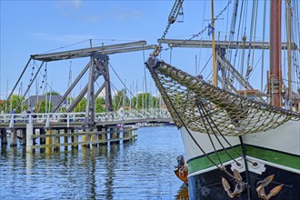 Bowsprit and bow of a sailing ship against the picturesque backdrop of Greifswald Wieck town