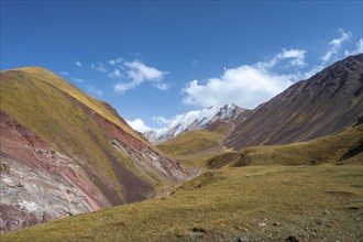 Valley with mountain stream between high mountains in autumn, mountain landscape with glaciated