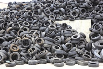 Old car tyres lie on stockpiles for recycling