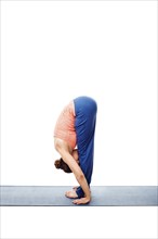 Woman doing Ashtanga Vinyasa Yoga Surya Namaskar Sun Salutation asana uttanasana, standing forward