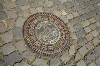 Manhole cover with inscription Water is life and water tower as landmark, Mannheim water supply,