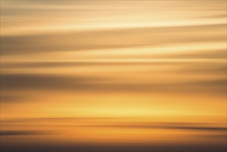 Orange-coloured evening sky with clouds near Lüneburg shortly after sunset, wiping effect, Lower